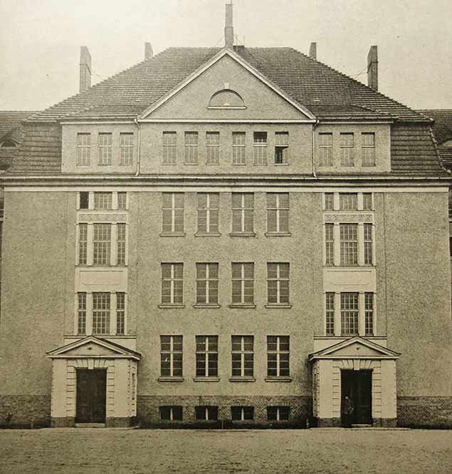 Historisches Foto des Mannschaftsgebäudes in Wünsdorf. Man sieht den Mittelteil des Gebäudes. Das Bild ist in sepia getönt.