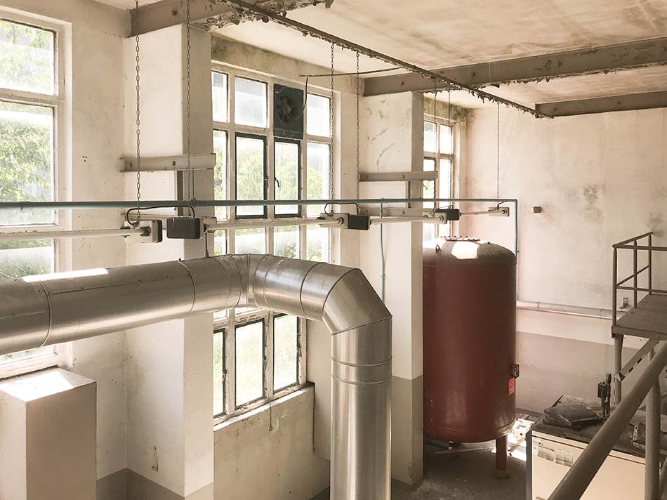 Jugendclub-Innenansicht, Tank in braunrot, viele Rohre, bröckelnder Putz