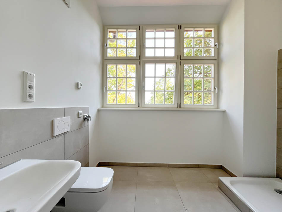 Badezimmer mit Duschnische, Waschbecken und und Toilette