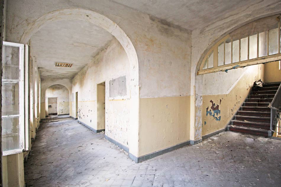 Fluransicht des ehemaliges Stabshauses auf dem Gelände der ehemaligen Infanterieschule Wünsdorf in weißem und ockerfarbenem, abbläterndem Putz