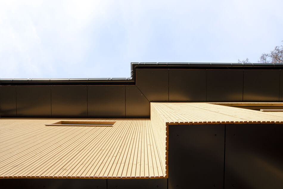 Blick von unten nach oben unter das herauskragende Dach.