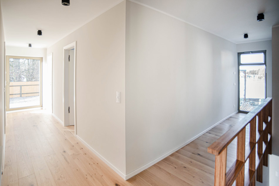 Flur im ersten Obergeschoss mit Treppengeländer aus Holz.