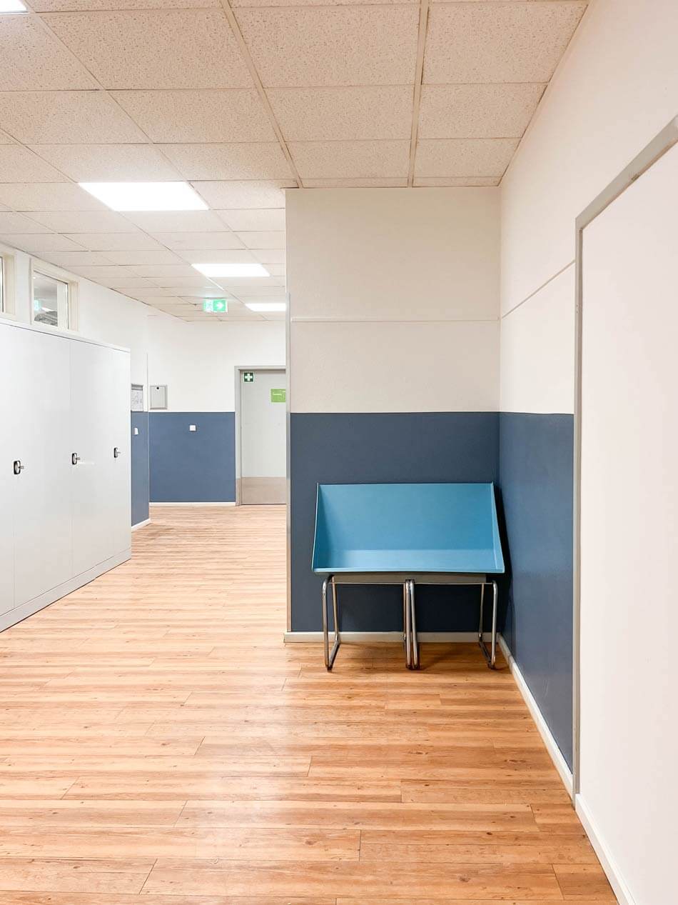 KUEH22-62_cubus-plan Flur der Quinoa-Schule mit Sitzmöbel in blau